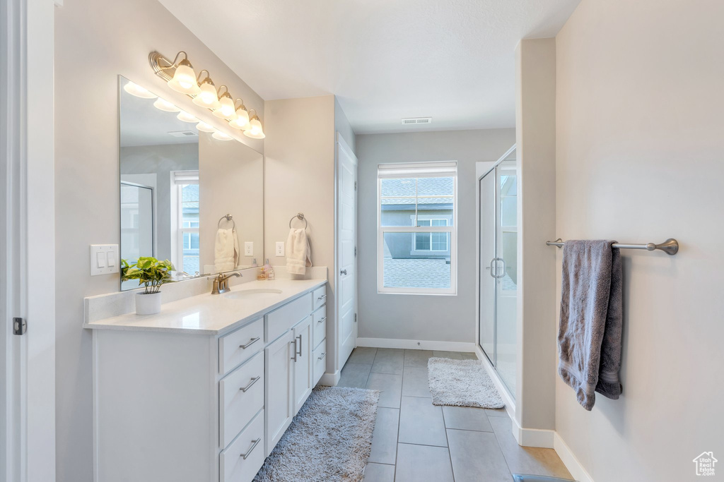 Full bathroom with plenty of natural light, vanity, tile patterned floors, and a stall shower
