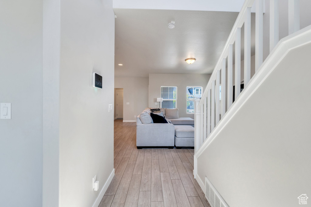Hall with baseboards, wood finished floors, and recessed lighting