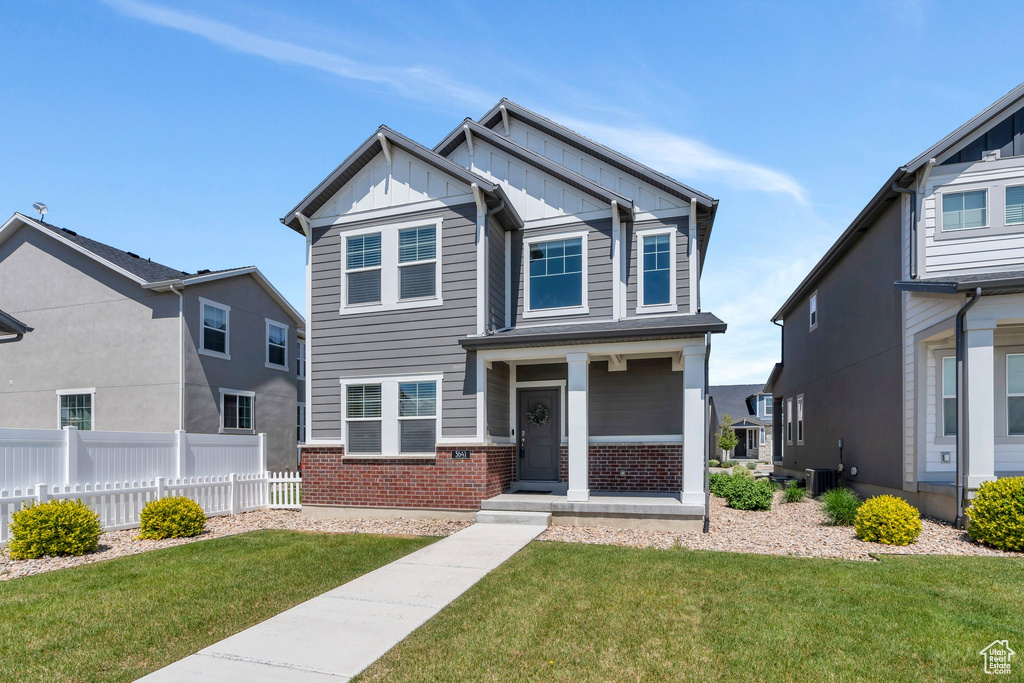 Craftsman-style home featuring board and batten siding, brick siding, central AC, and covered porch