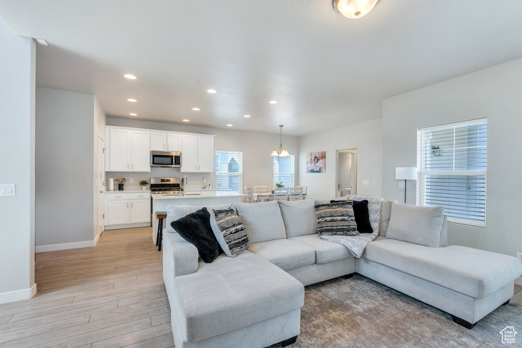 Living room with light wood-style flooring, recessed lighting, and baseboards