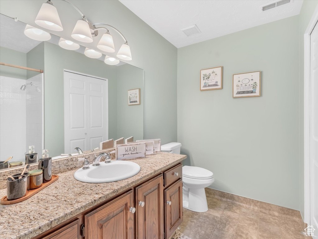 Full bath featuring toilet, vanity, a shower, a chandelier, and baseboards