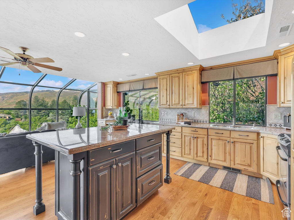 Kitchen featuring a sink, light wood-type flooring, stainless steel electric range, decorative backsplash, and recessed lighting