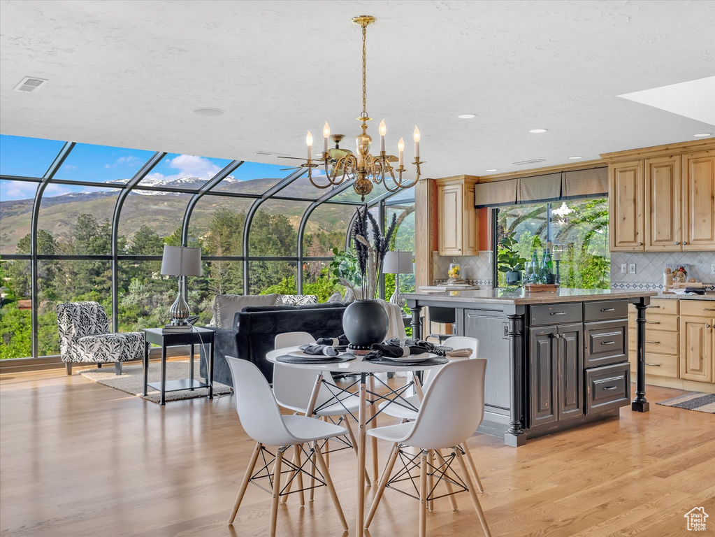 Dining room with light wood-style floors, a chandelier, and recessed lighting