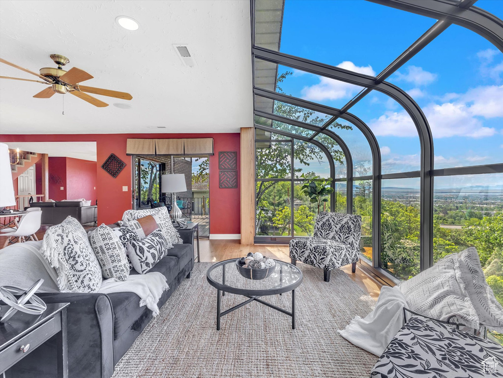 Living room with a sunroom, ceiling fan, wood finished floors, and recessed lighting
