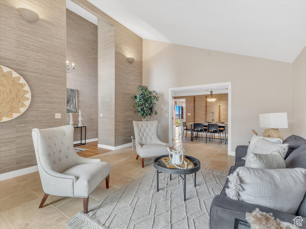 Tiled living room featuring baseboards and high vaulted ceiling