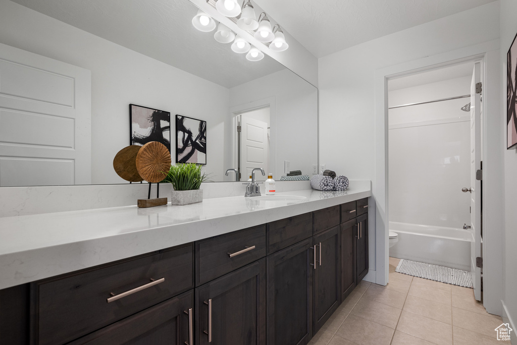 Full bath featuring tile patterned floors, vanity, toilet, and shower / tub combination