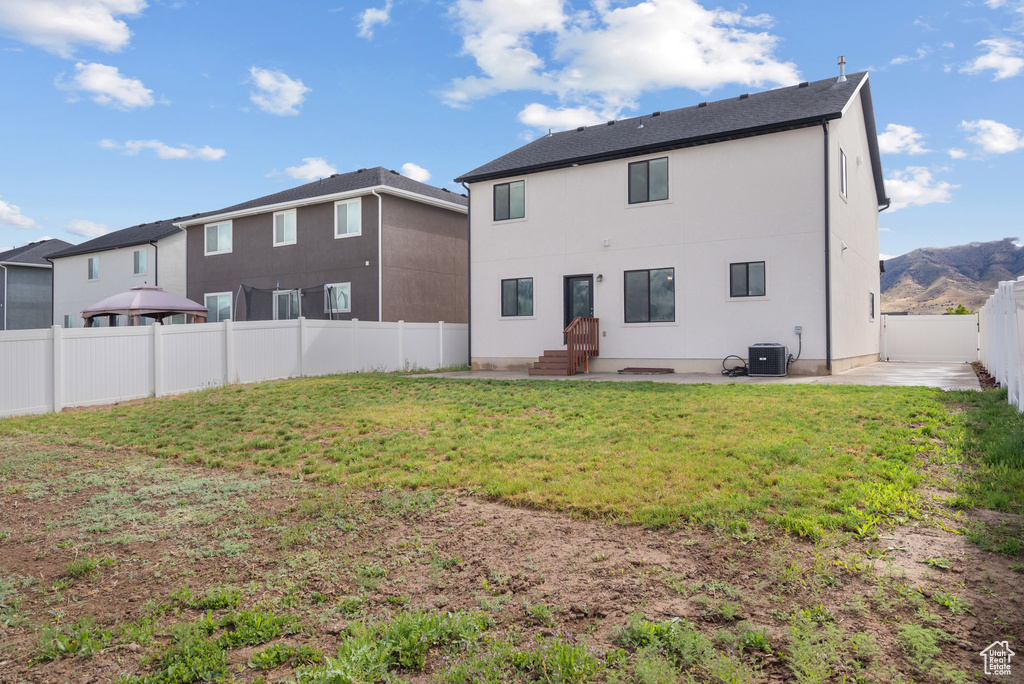 Rear view of house featuring cooling unit, a patio area, and stucco siding