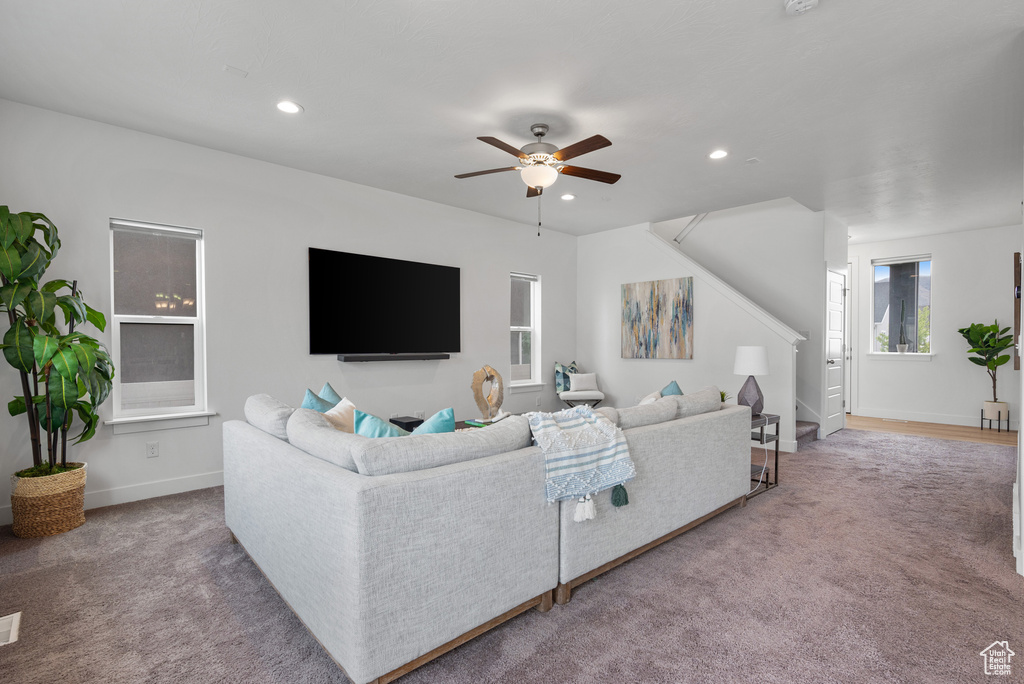 Carpeted living room with stairs, a ceiling fan, recessed lighting, and baseboards