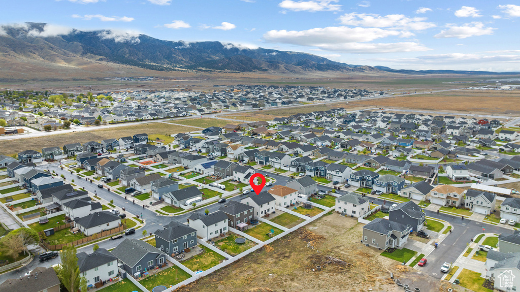 Aerial view of property and surrounding area with nearby suburban area and a mountain backdrop