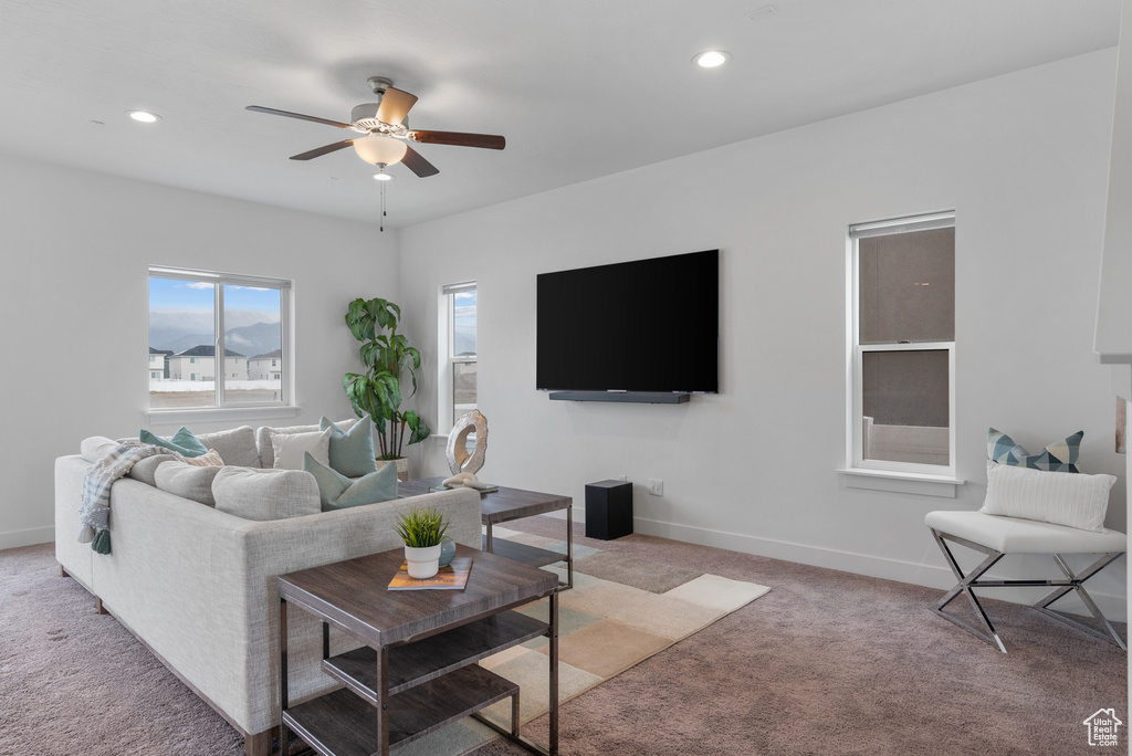 Living area with light colored carpet, a ceiling fan, recessed lighting, and baseboards