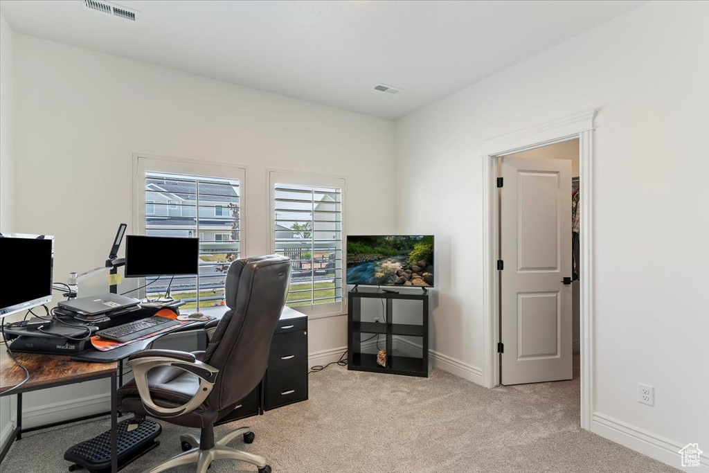 Home office featuring light colored carpet and baseboards