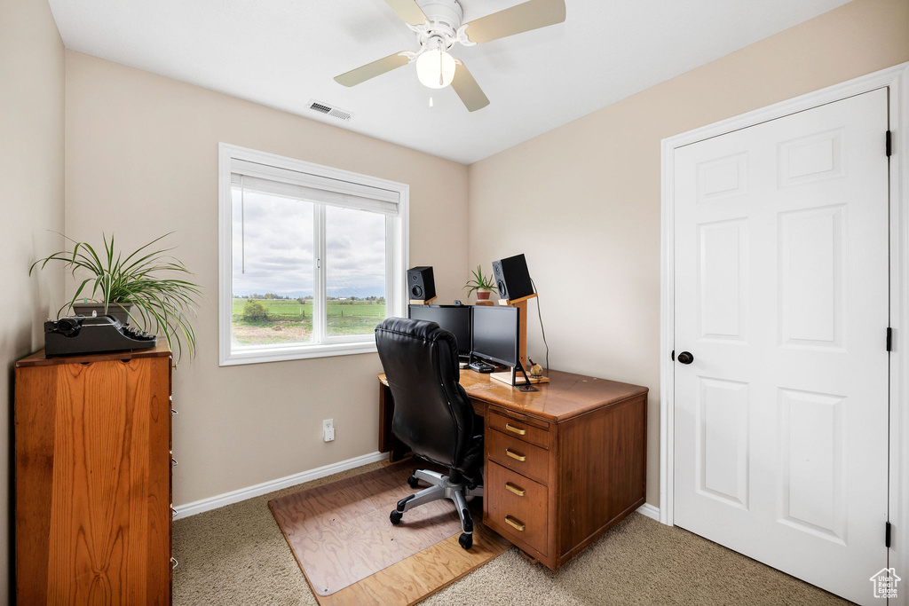 Office space with baseboards, a ceiling fan, and light colored carpet