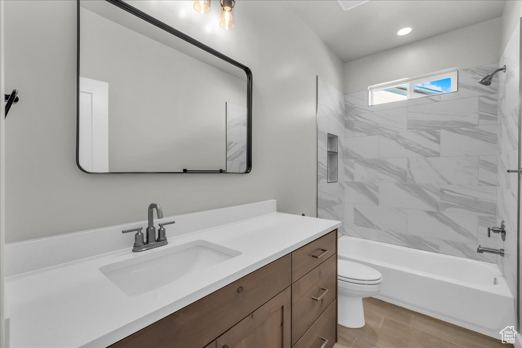Full bathroom with vanity, toilet,  shower combination, and recessed lighting