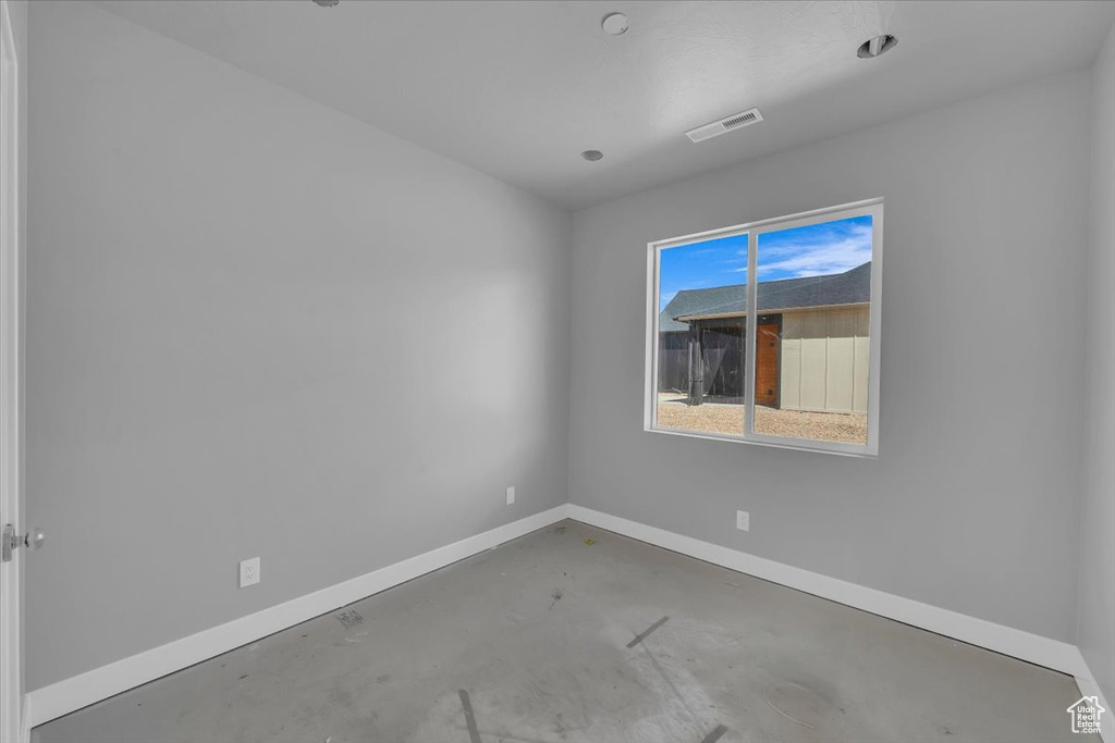 Unfurnished room with concrete flooring and baseboards