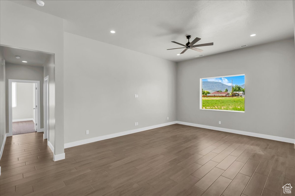 Unfurnished room featuring dark wood-style floors, ceiling fan, recessed lighting, and baseboards