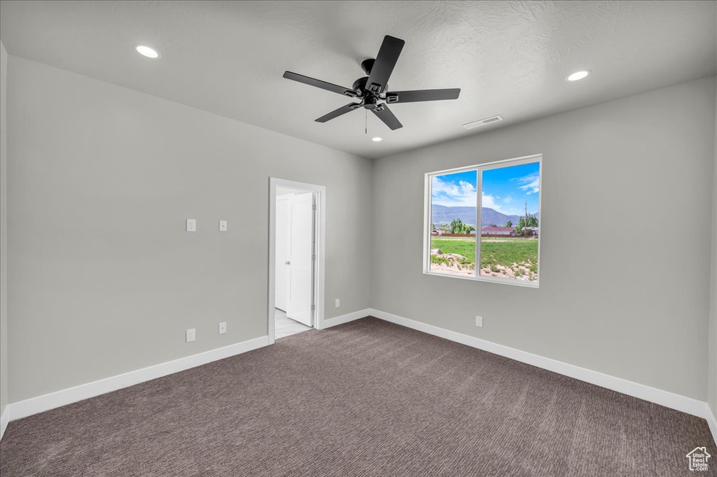 Unfurnished room featuring dark carpet, a ceiling fan, baseboards, and recessed lighting