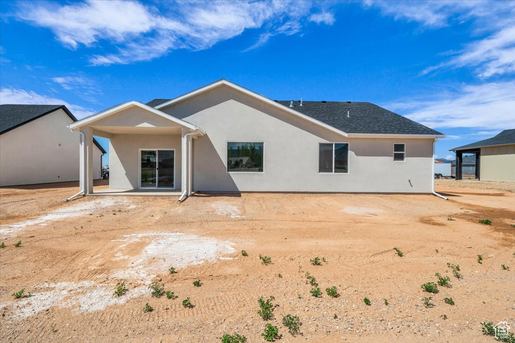 Back of property featuring stucco siding and a patio