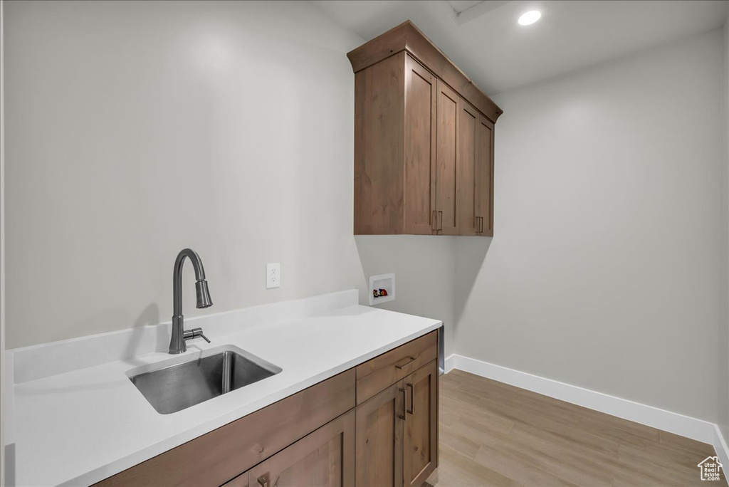 Laundry room featuring washer hookup, light wood-style flooring, cabinet space, baseboards, and recessed lighting