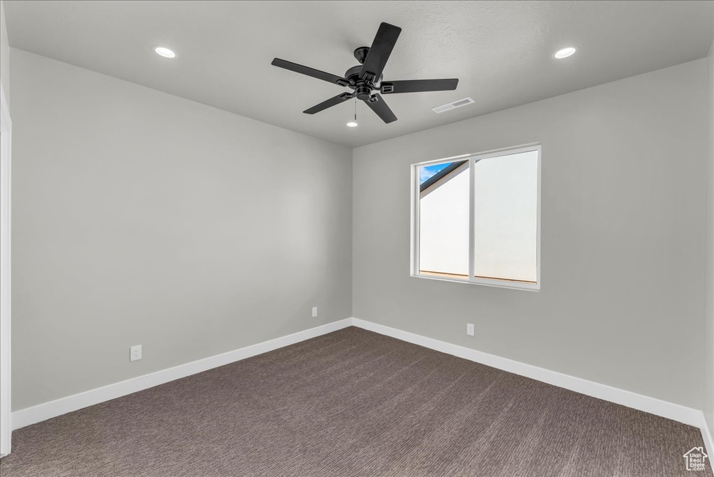 Spare room featuring recessed lighting, baseboards, dark colored carpet, and a ceiling fan