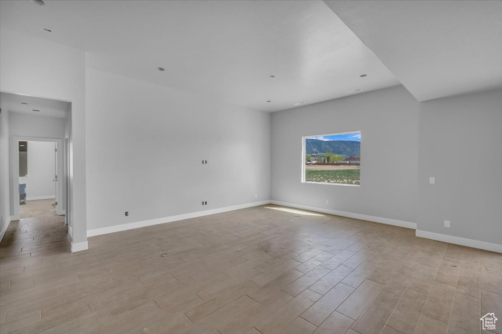 Spare room featuring baseboards and light wood-style floors