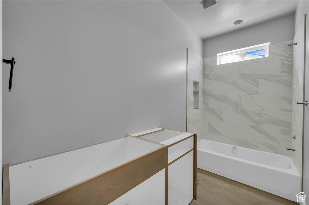 Full bath featuring shower / bathtub combination and wood finished floors