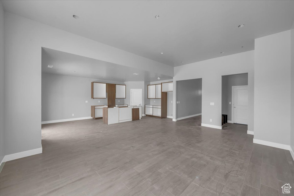 Unfurnished living room featuring baseboards and wood finished floors