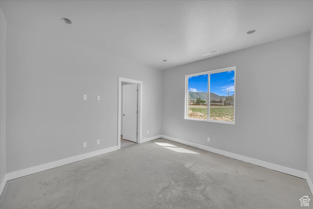 Empty room featuring concrete floors and baseboards