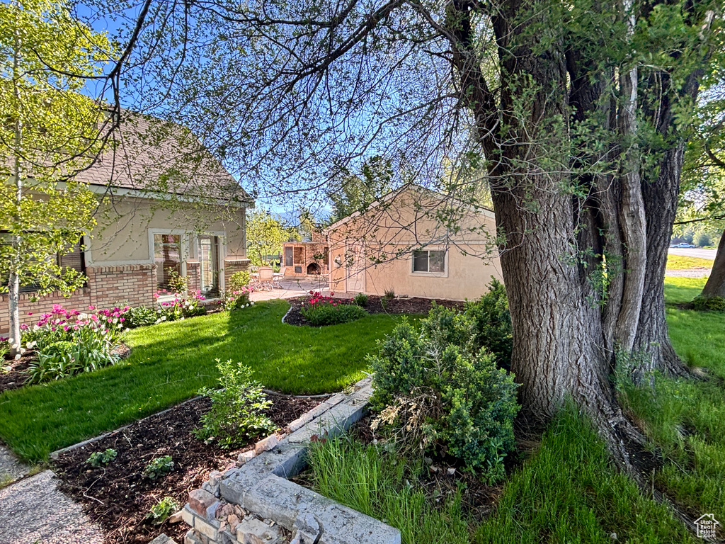 View of grassy yard featuring a patio area