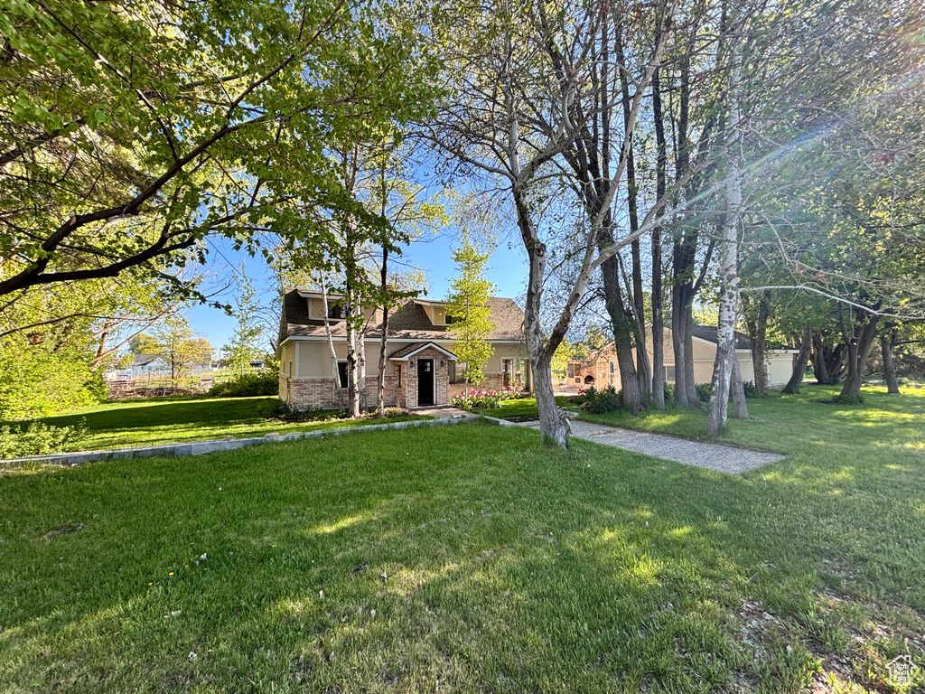 View of front facade featuring a front lawn and stone siding