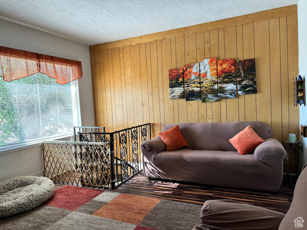 Living room with wood walls and a textured ceiling