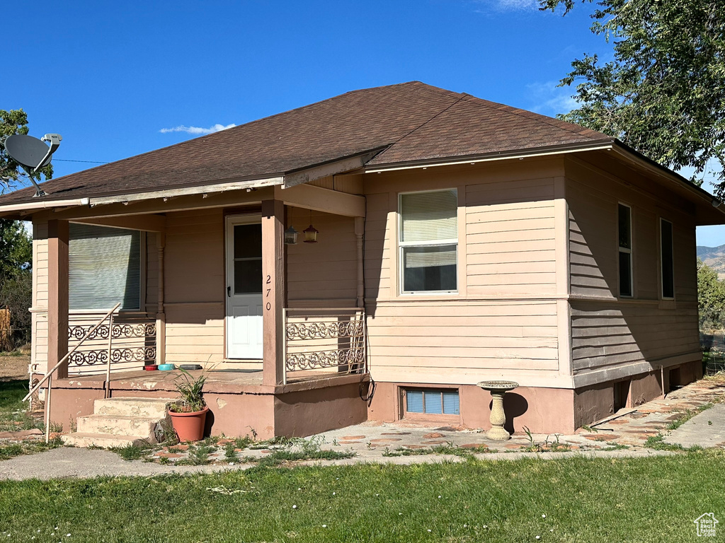 View of front facade with roof with shingles and covered porch