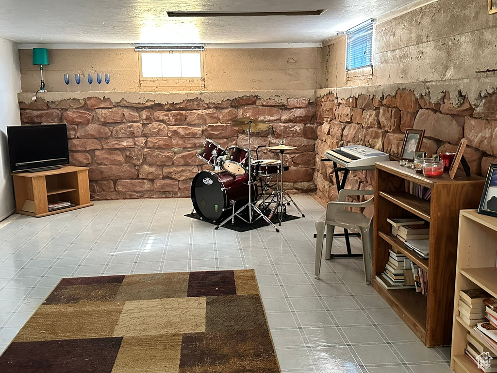 Basement featuring tile patterned floors and a textured ceiling