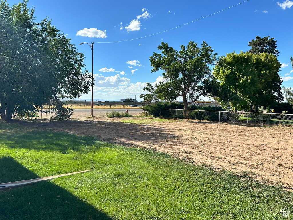 View of yard with fence and a view of rural / pastoral area