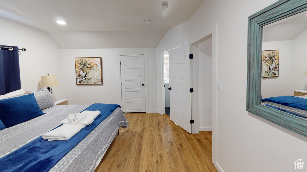 Bedroom featuring vaulted ceiling, light wood-type flooring, recessed lighting, and baseboards