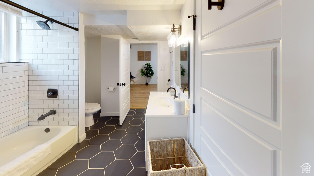 Full bathroom featuring toilet, tile patterned floors, and vanity