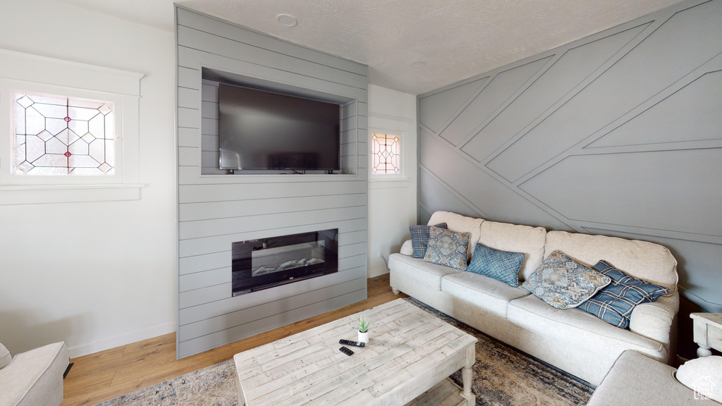 Living area featuring wood finished floors, baseboards, and a fireplace