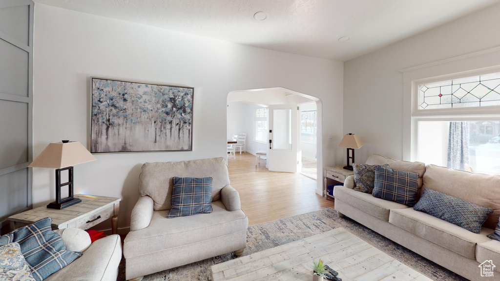 Living room with arched walkways and wood finished floors