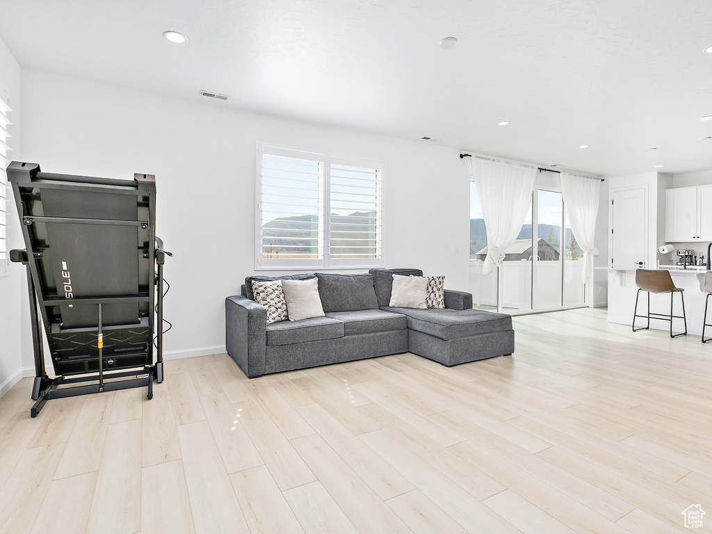 Living room featuring light wood-type flooring, recessed lighting, and baseboards