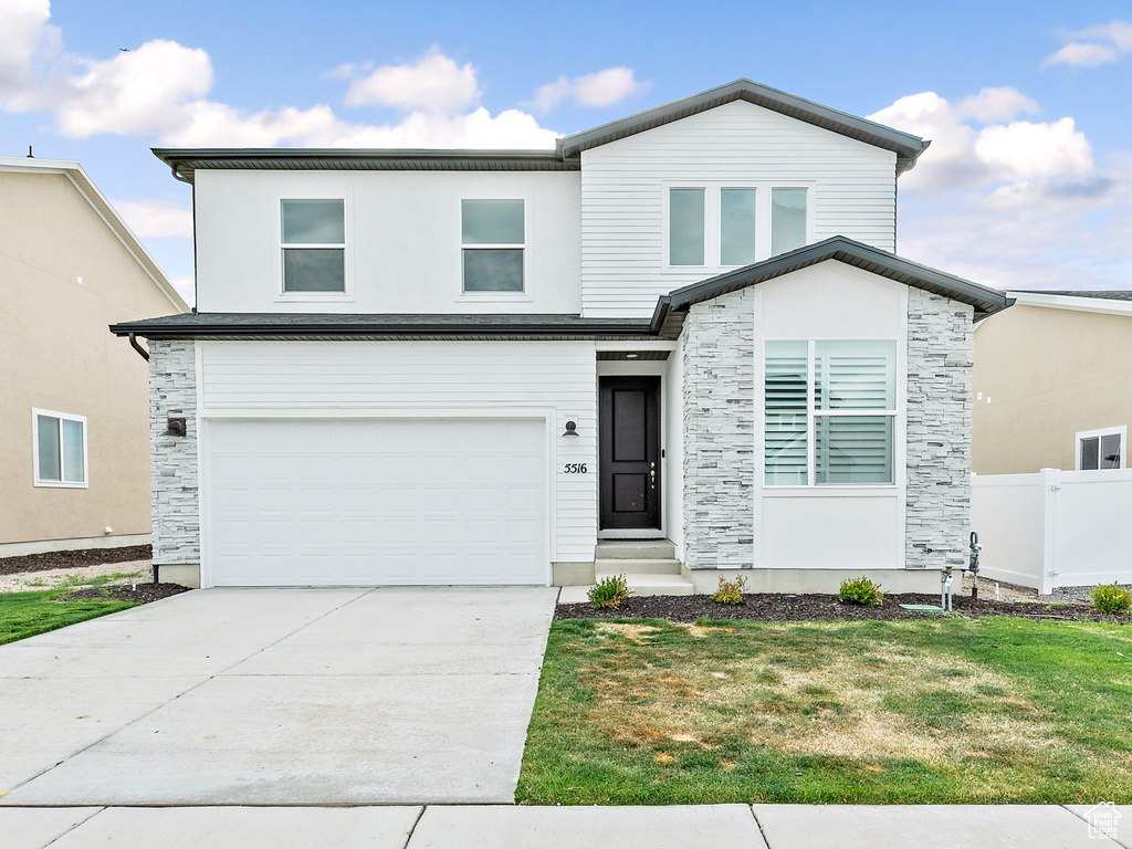 Contemporary home featuring stone siding, an attached garage, and concrete driveway