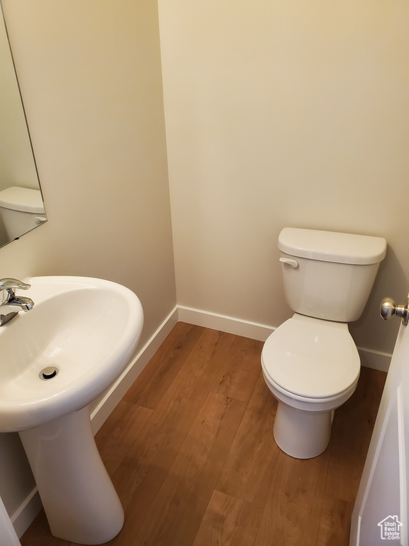 Bathroom with baseboards, toilet, and wood finished floors