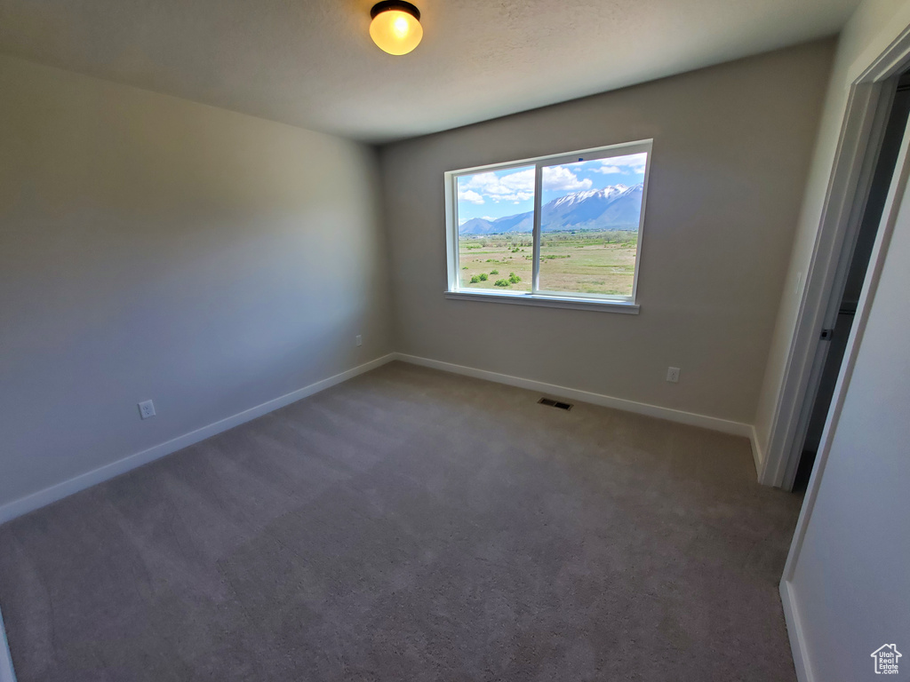 Carpeted empty room featuring baseboards