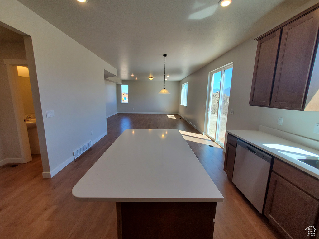Kitchen with dishwasher, wood finished floors, light countertops, and recessed lighting