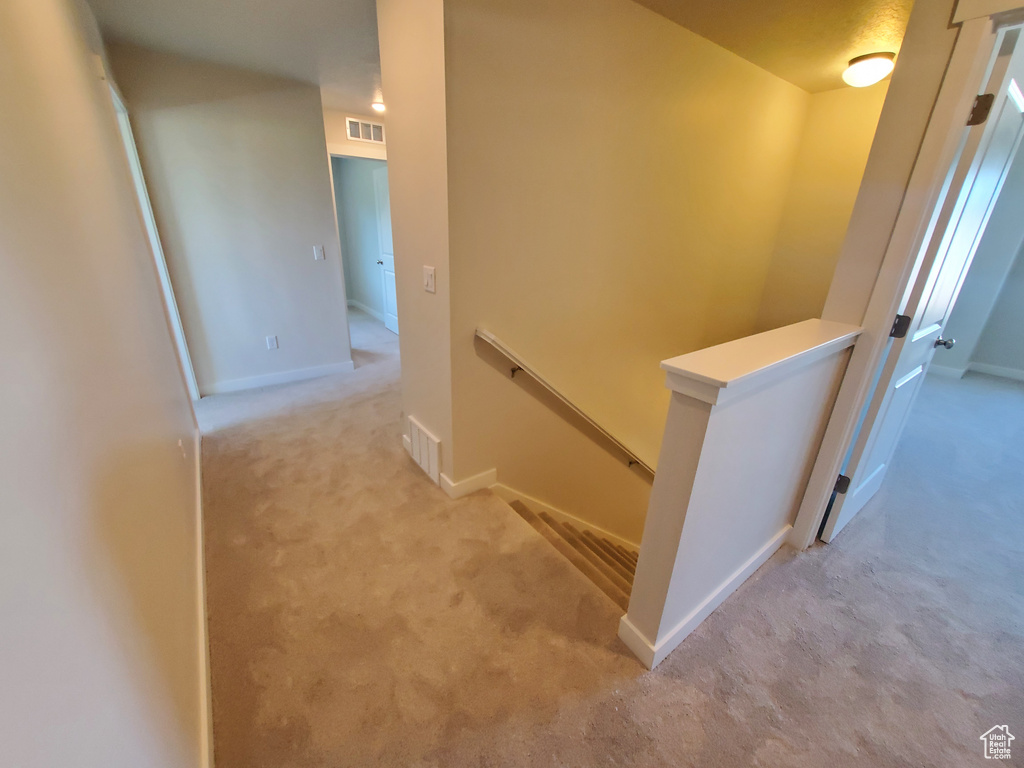 Hall featuring an upstairs landing, carpet, and baseboards