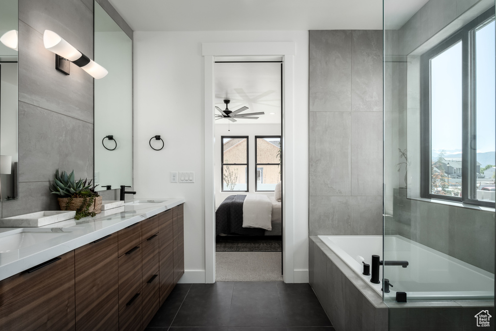 Ensuite bathroom featuring plenty of natural light, ceiling fan, tile patterned flooring, and double vanity