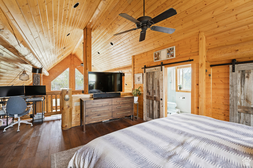 Bedroom featuring a barn door, wood walls, hardwood / wood-style floors, vaulted ceiling, and wooden ceiling