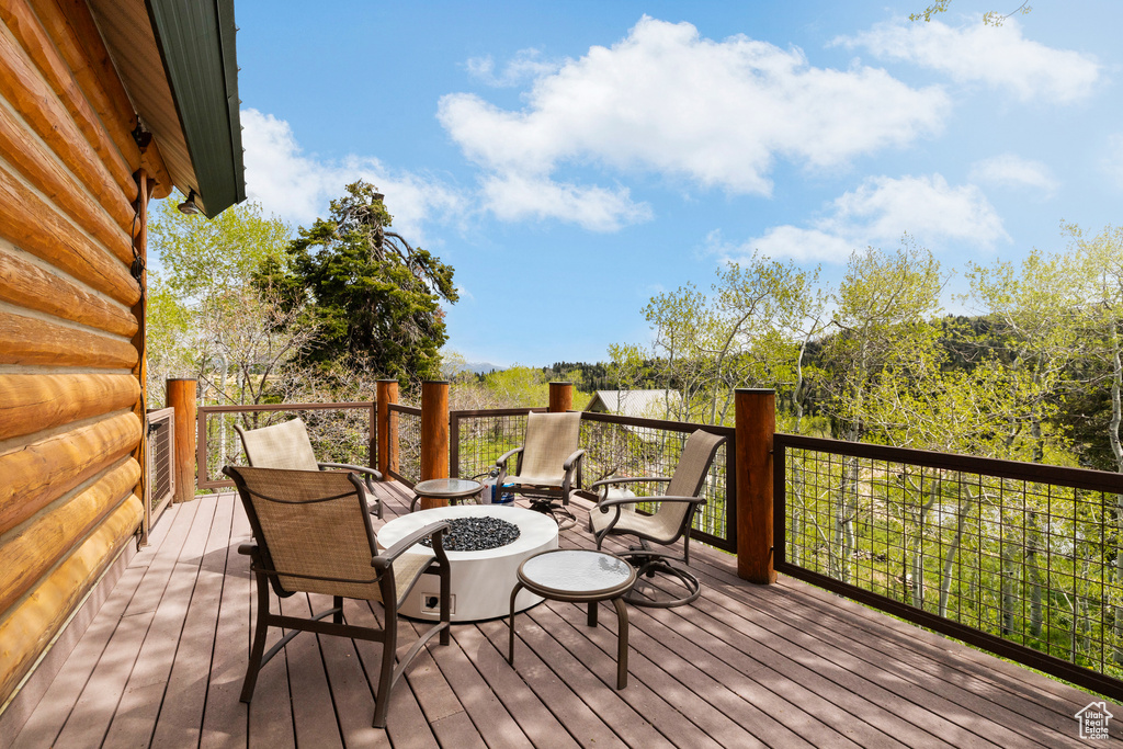 Wooden deck featuring an outdoor fire pit