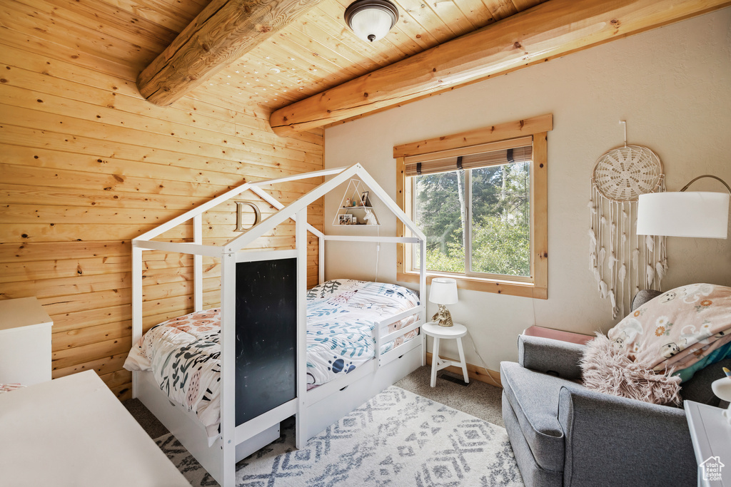 Carpeted bedroom featuring wooden ceiling with exposed beams
