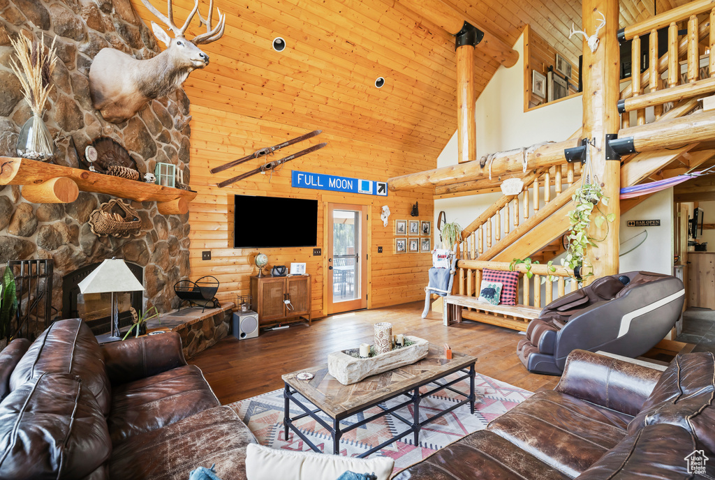 Living area featuring high vaulted ceiling, wood-type flooring, a fireplace, and wooden ceiling