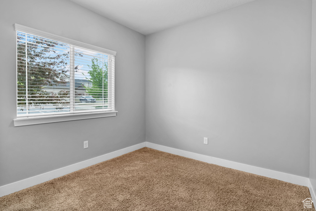 Carpeted spare room with baseboards