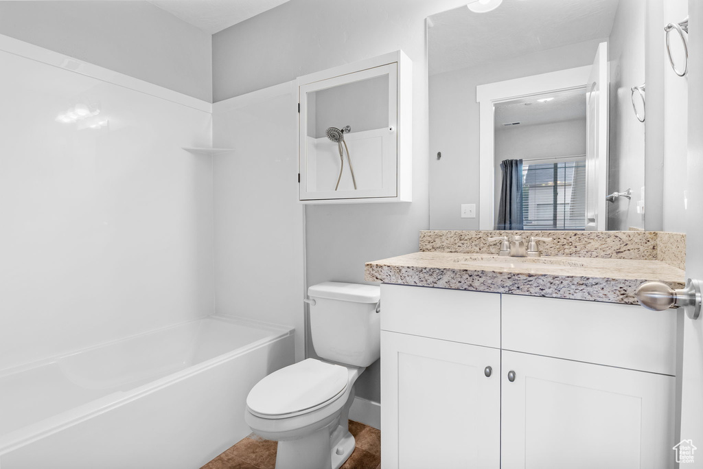 Bathroom featuring toilet, vanity, and shower / tub combination